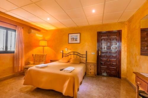 Mollina莫利诺萨多酒店的一间拥有黄色墙壁的卧室和一张位于客房内的床