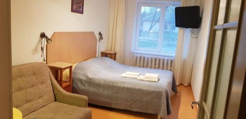 维尔纽斯菲尔伽酒店的一间卧室配有一张床、一把椅子和电视