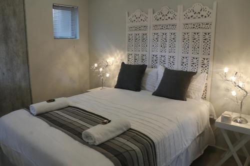 哈特比斯普特Millennium Body Guards Guesthouse的一间卧室配有一张带两盏灯的大型白色床。