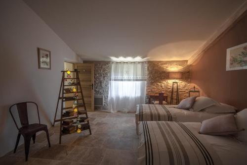 博尼约La Ressence Luberon的一间卧室设有两张床和一个装有葡萄酒瓶的架子。
