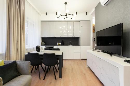 维尔纽斯Luxury for everyone - Hills Park Lux Apartments 2的厨房以及带桌椅的起居室。