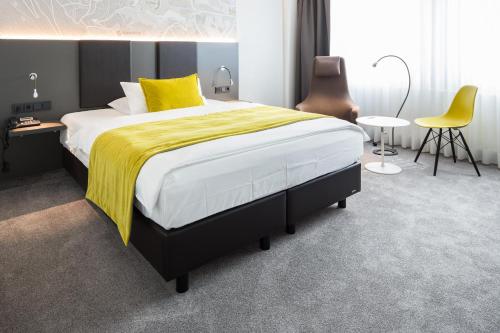 卡塞尔FischerS - Kurparkhotel Bad Wilhelmshöhe的一间卧室配有一张带黄色毯子的大床