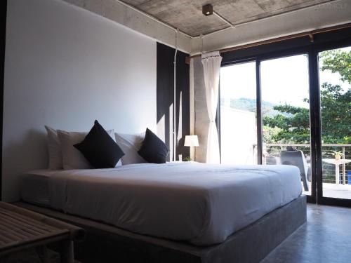 涛岛Samatha Bed & Breakfast的卧室设有一张大白色的床和大窗户