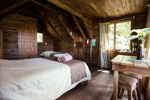 Tres de Junio帕拉伊索格查尔酒店的小木屋内一间卧室,配有两张床