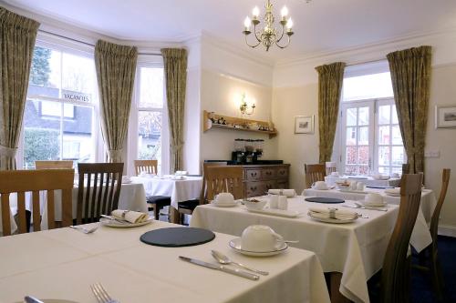 凯西克桑尼塞得旅馆的餐厅设有白色的桌椅和窗户。