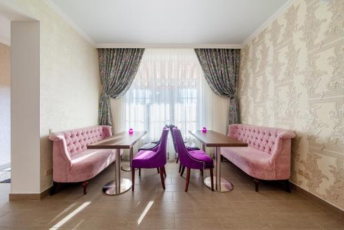克拉斯诺达尔D Hotel的一间设有两张桌子和紫色椅子的用餐室