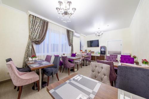 克拉斯诺达尔D Hotel的一间带桌子和紫色椅子的用餐室