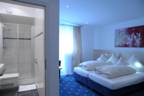 卡尔斯鲁厄斯图尔曼酒店-餐厅的一间卧室配有一张床,浴室设有淋浴。