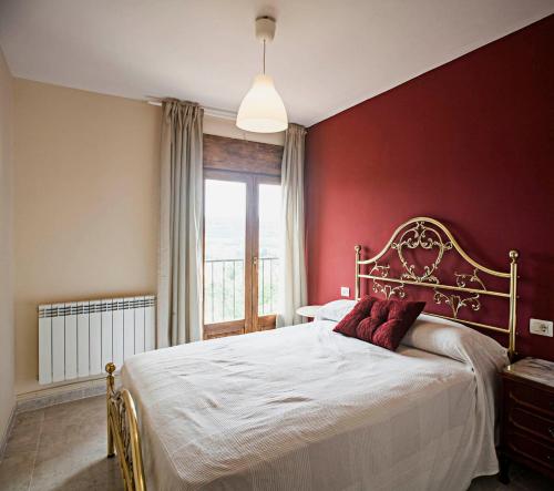努瓦洛斯Casa rural la Era del Malaño的一间卧室设有一张红色墙壁的大床