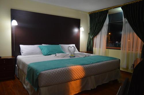 拉塔昆加Balcones del Río Hotel的一间卧室设有一张大床和一个窗户。