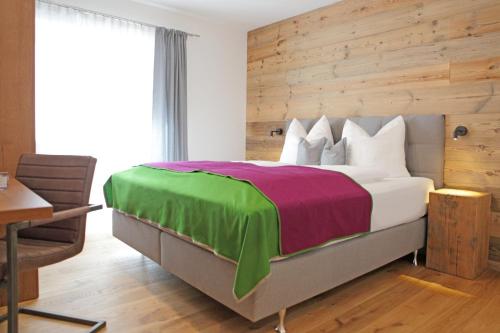 阿尔滕马克特蓬高Appartementhaus Reiter Village Room的一间卧室设有一张带木墙的大床