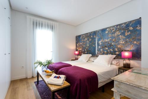 塞维利亚Apartamentos RG Plaza de España的一间卧室配有一张大床和紫色毯子