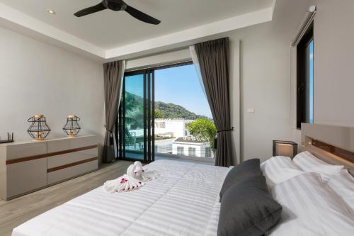 卡塔海滩Twin Villas Seaview Kata的卧室设有一张白色大床和大窗户