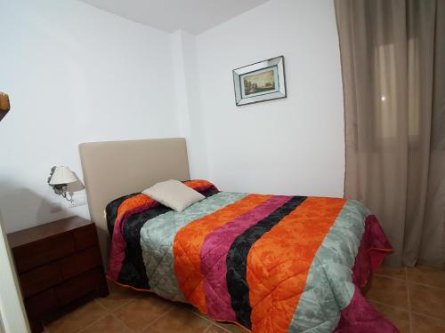RíogordoHostal Mesón La Era的一间卧室配有一张带彩色毯子的床