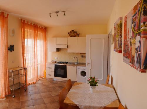 加利波利Tramonto -Appartamenti OltreMare- Lido Conchiglie Gallipoli的一间带桌子的厨房和一间带桌椅的厨房