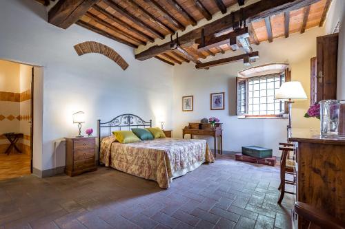 瓦尔的圣卡西亚诺安德烈亚别墅 的一间卧室配有一张床、一张桌子和一个窗户。