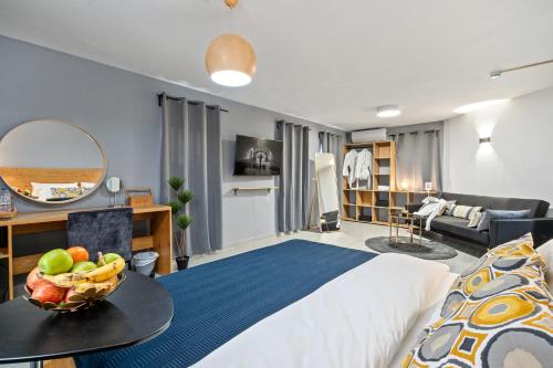 贝尔谢巴מלון לה פינקה - מלון סוויטות יוקרתי的一间卧室配有一张床,桌上放着一碗水果