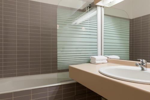 圣马丁杜维维La Berteliere, The Originals Relais (Qualys-Hotel)的一间带水槽和镜子的浴室