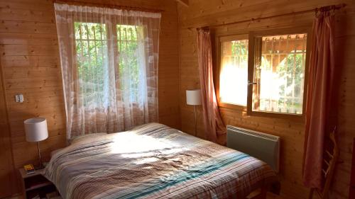 Collonges-sous-Salève吉特斯乐全景度假屋的小木屋内一间卧室配有床和窗户