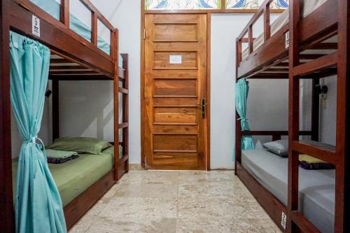 日惹鲁玛班加坦旅馆的带两张双层床和一扇门的房间