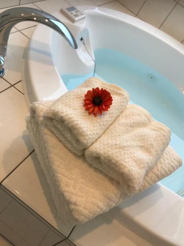 今归仁村シーブリーズ古宇利的浴缸上带红花的毛巾