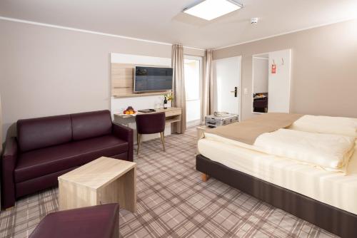 梅彭泰克高级酒店的酒店客房配有一张床、一张沙发和一张书桌。