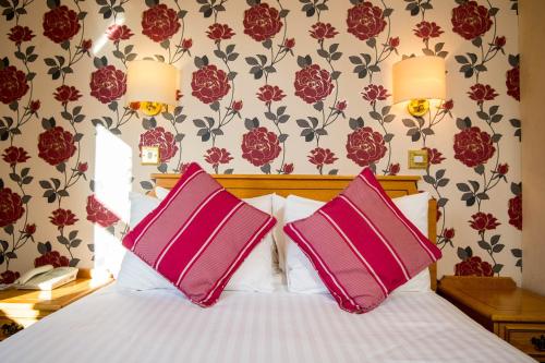 卡马森Ivy Bush Royal Hotel by Compass Hospitality的一间卧室配有一张带两个粉红色枕头的床