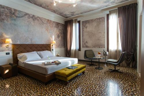 威尼斯Riva del Vin BOUTIQUE HOTEL的配有一张床和一把椅子的酒店客房