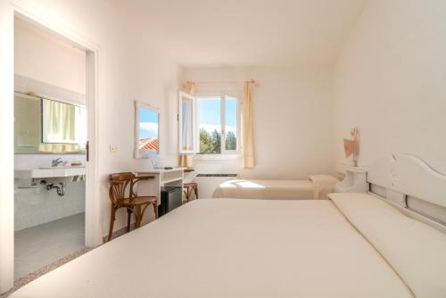 巴哈撒丁岛博​​迪3号酒店的白色卧室配有床和书桌