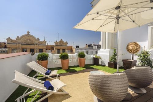 马德里女王别墅H10精品酒店的屋顶上带椅子和遮阳伞的天井