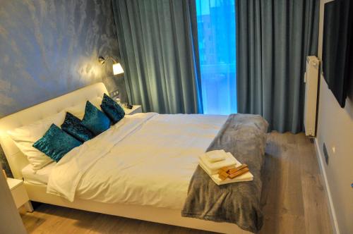 绿山城Verde Apartment的一间卧室配有白色床和蓝色枕头