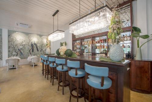 琅勃拉邦飞天酒店的餐厅内带蓝色酒吧凳的酒吧