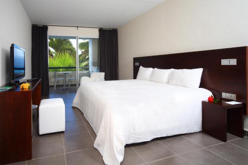 哥西尔红木公寓SPA酒店的卧室配有一张白色大床和电视。