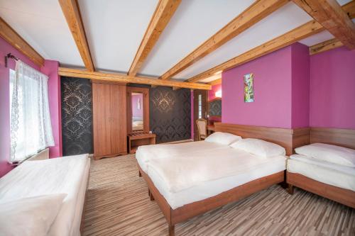 斯托尼拉斯奇Dworek Galosa的一间卧室设有两张床和紫色墙壁