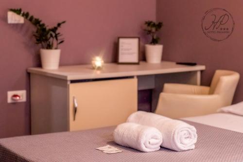 佛罗伦萨帕格尼尼酒店的一间客房,配有一张桌子和一张床上的两条毛巾