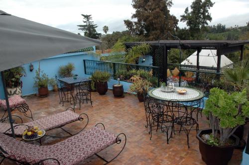 梅克内斯里亚德拉哈布勒酒店的庭院配有桌椅和桌椅。