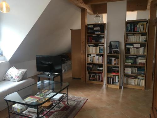 慕尼黑Helle und ruhige Dachgeschosswohnung的带沙发和玻璃桌的客厅