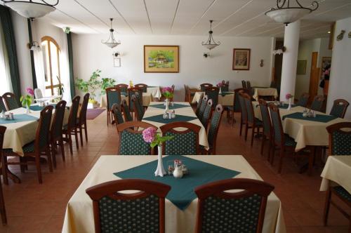 赫维兹Ágnes Hotel的用餐室配有桌椅和鲜花