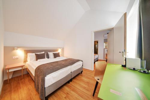 艾斯特根Fekete Sas Motel的一间卧室配有一张床和一张书桌及电视