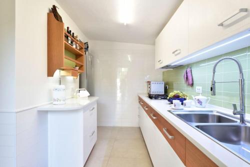 托尔托利VILLA MILVIO con accesso privato in spiaggia的白色的厨房设有水槽和台面