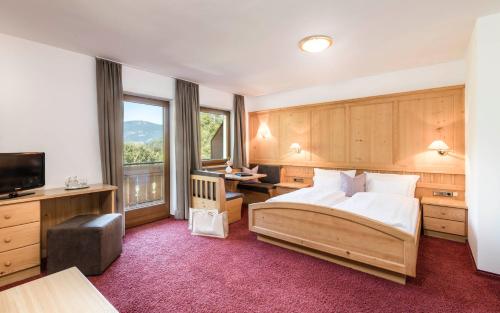 拉伊翁Hotel Weisses Rössl 3Sup的一间卧室设有一张床和一个大窗户