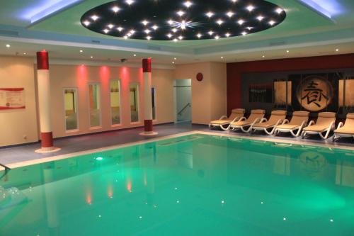 于克里茨DAS HUDEWALD Hotel & Resort的一座带椅子和天花板的酒店游泳池