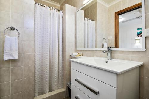 豪勋爵岛洛希提公寓的浴室设有白色水槽和镜子