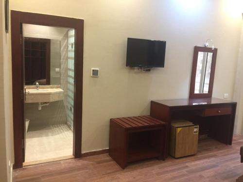 开罗Grand Palace Hotel的一间带镜子和水槽的浴室以及一台电视