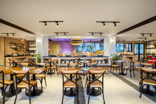 坤甸ibis Pontianak City Center的一间带桌椅的餐厅和一间酒吧