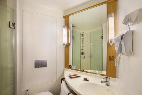 坤甸ibis Pontianak City Center的一间带水槽、卫生间和镜子的浴室