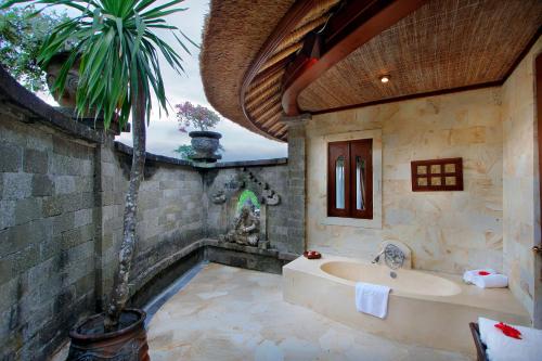 NegaraTaman Wana Resort Palasari的带浴缸和棕榈树的浴室