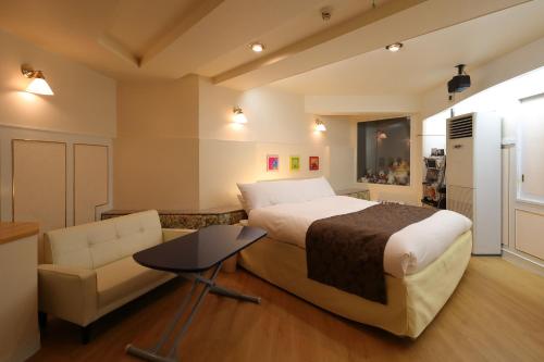 冈山Hotel Fine Garden Okayama I的一间卧室配有一张床、一张沙发和一把椅子