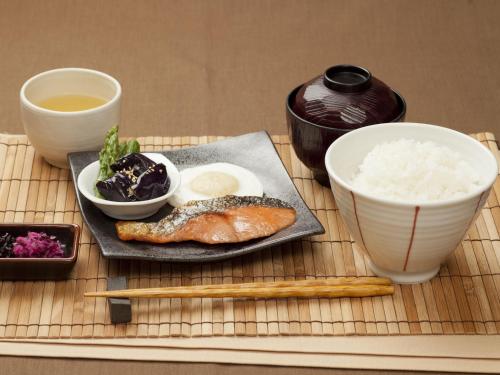 冈山Hotel Fine Garden Okayama I的一张桌子,上面放着一盘食物和一碗米