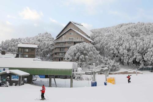 福尔斯克里克Les Chalets 20的两人在滑雪小屋前的雪地滑雪